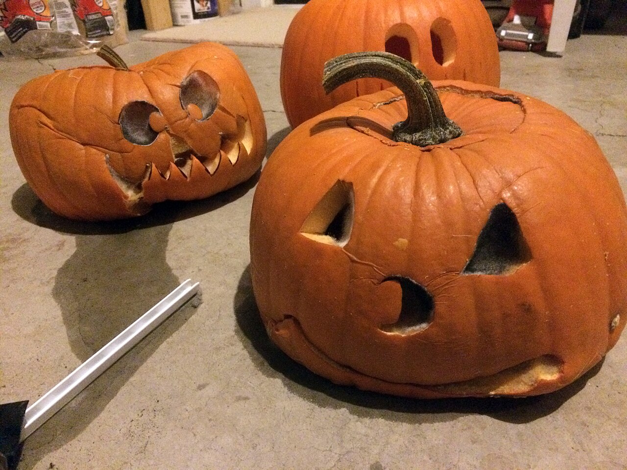 A carved jack-o'-lantern collapsing and caving in on itself as it rots